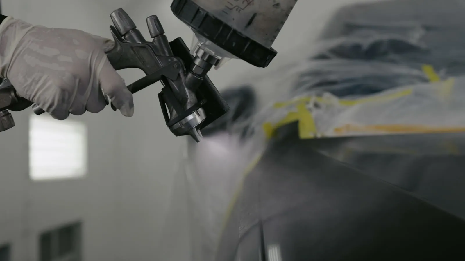 Spray gun applying Peel Clear